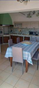 a kitchen with a table with chairs and a blue and white table cloth at Nerissa apartments in Terrasini
