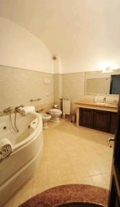a bathroom with a tub and a toilet and a sink at Nerissa apartments in Terrasini