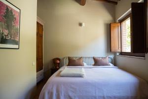 a bedroom with a bed with white sheets and a window at Boutique Bio Agriturismo Casale San Cristoforo in Città di Castello