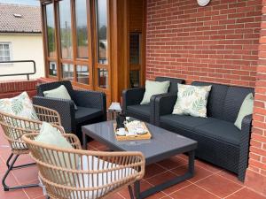 a patio with couches and a table and chairs at La CASA ROJA SOLARES in Solares