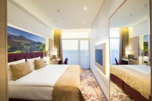 ユールマラにあるLielupe Hotel SPA & Conferences by Semarahのベッド2台と大きな窓が備わるホテルルームです。