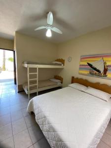 a bedroom with a bed and a ceiling fan at Maré Alta 400 mt da praia de Maresias in Maresias +56 photos