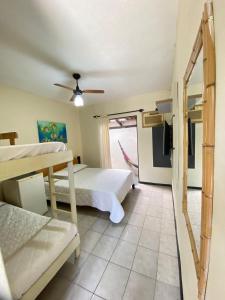 a bedroom with two beds and a ceiling fan at Maré Alta 400 mt da praia de Maresias in Maresias