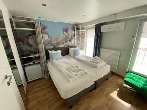 a small bedroom with a bed with a mirror at Hotel De Backer in Knokke-Heist
