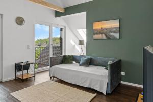 a living room with a couch and a large window at Loftbude in Hürth