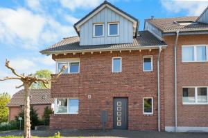 a red brick house with a grey roof at Loftbude in Hürth