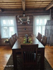 a dining room with a wooden table and chairs at Erämökki Puruveden rannalla in Vaara