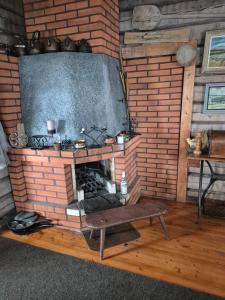 a living room with a brick fireplace with a tv at Erämökki Puruveden rannalla in Vaara