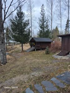 a cabin in the woods with a table and stairs at Erämökki Puruveden rannalla in Vaara +34 photos