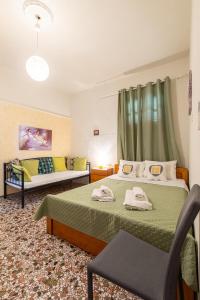 a bedroom with two beds and a couch at House Klimataria Kamilari in Kamilari