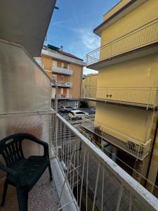 a black chair sitting on the balcony of a building at Hotel & Trattoria Le Caravelle in Lavagna +22 photos