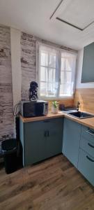 a kitchen with a sink and a microwave on a counter at Charmant studio in Vernon