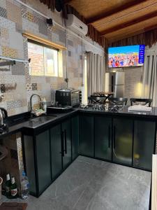 a kitchen with green cabinets and a flat screen tv at Casa Versatil in Chuí +14 photos