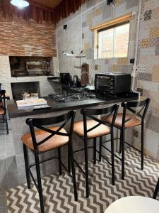 a kitchen with a table with chairs and a microwave at Casa Versatil in Chuí