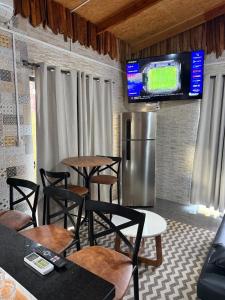 a restaurant with chairs and a refrigerator and a tv at Casa Versatil in Chuí