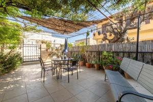 a patio with a table and chairs and a fence at House Klimataria Kamilari in Kamilari
