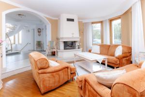 a living room with orange furniture and a fireplace at Villa Cetatuia in Cluj-Napoca