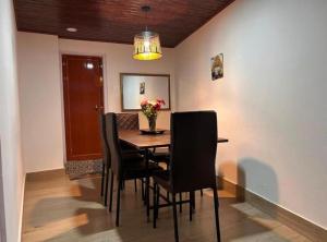 a dining room table with chairs and a vase of flowers at The Boho Darjeeling Stays in Darjeeling