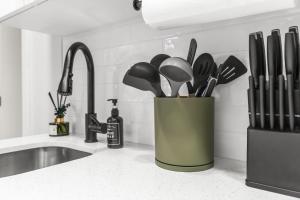a kitchen counter with a container of kitchen utensils at Bayview Apartments By Lowkl in Fort Lauderdale +49 photos