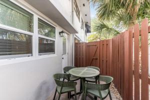 a patio with a table and chairs and a fence at Bayview Apartments By Lowkl in Fort Lauderdale