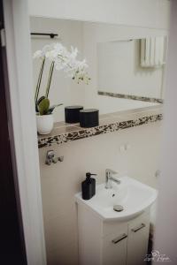 a white bathroom with a sink and a mirror at Mazurska przystań in Ryn