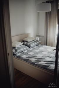 a bed with two pillows on it in a room at Mazurska przystań in Ryn