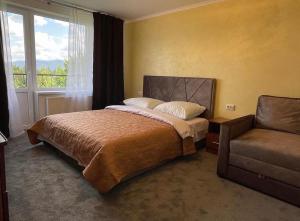 a bedroom with a bed and a chair and a window at Квітуча Гора Double Room in Lazeshchyna