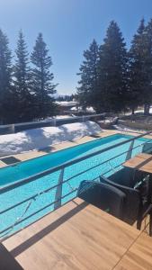 a swimming pool with tables and chairs and trees at DFJ des Neiges, Piscine, Pieds des pistes in Chamrousse