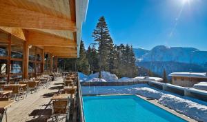 a resort with a swimming pool with mountains in the background at DFJ des Neiges, Piscine, Pieds des pistes in Chamrousse