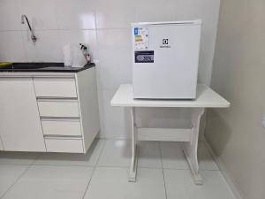 a white refrigerator sitting on a table in a kitchen at Hotel Fazenda Arena Green in Cajazeiras +39 photos