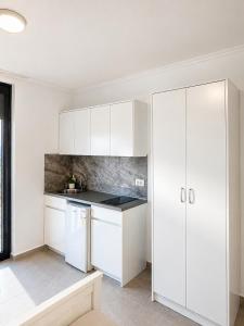 a white kitchen with white cabinets at Horizont Dobre Vode in Dobra Voda