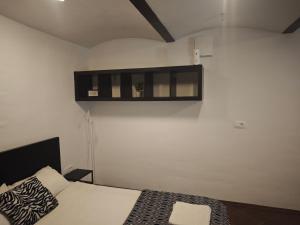 a bedroom with a bed and a shelf on the wall at Apartmaji pr'Muranček in Radovljica