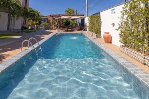 a swimming pool in a house at Altos do Caju - Triplex in Pirangi 300 meters from the World's Largest Cashew Tree by Carpediem in Parnamirim