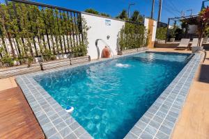 a swimming pool with blue water in front of a fence at Altos do Caju - Triplex in Pirangi 300 meters from the World's Largest Cashew Tree by Carpediem in Parnamirim