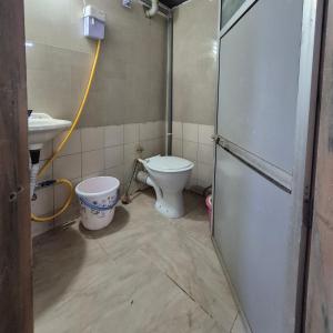 a bathroom with a toilet and a sink at Swami Single Bed Dormstay in Ratnagiri