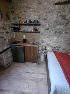 a bedroom with a sink and a stone wall at lefkara stone nest in Pano Lefkara