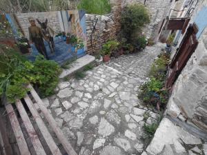 a stone pathway with a painting of a man on a wall at lefkara stone nest in Pano Lefkara +3 photos