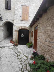 a stone building with a large door and flowers at lefkara stone nest in Pano Lefkara