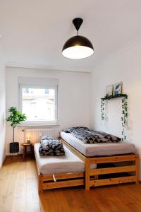 two beds in a room with a window at Living Lu - cosy Apartment three - nähe Mannheim - BASF - Netflix - 3 Zimmer in Ludwigshafen am Rhein