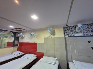 a room with two beds and a wall with dishes at Swami Single Bed Dormstay in Ratnagiri +2 photos