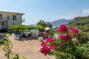 a yard with pink flowers and a house at Vida House in Borsh