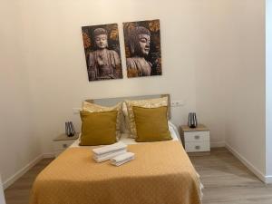 a bedroom with a bed with three pictures on the wall at Apartamento Vinoble Jerez in Jerez de la Frontera