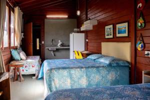 a bedroom with two beds and a refrigerator at Chalé com Piscina - Festival de Inverno de Bonito in Bonito