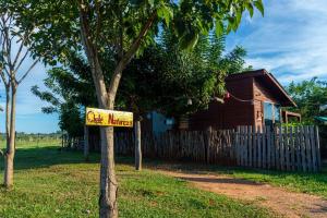 a sign in front of a house next to a tree at Chalé com Piscina - Festival de Inverno de Bonito in Bonito
