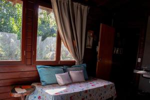 a room with a bed with pillows and two windows at Chalé com Piscina - Festival de Inverno de Bonito in Bonito +18 photos