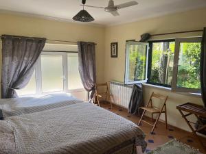 a bedroom with a bed and two chairs and windows at Casa Gaia in Serpins