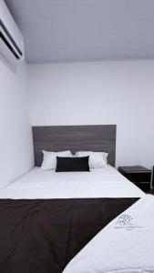 a bedroom with a large bed with white sheets at Hotel Logistico in Santa Marta