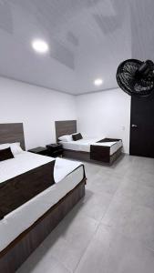 a hotel room with two beds and a fan at Hotel Logistico in Santa Marta +7 photos