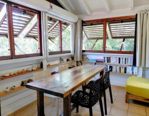 a dining room with a wooden table and chairs at GîteTi Coco de Malendure - Bord de mer - 4 pers in Bouillante