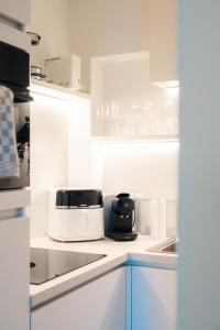 a kitchen with white cabinets and a toaster on a counter at Luxurious Suite - Train Station Deinze in Deinze